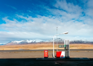 khamkeo-vilaysing-QfBAsUzsmgk-unsplash A single fuel pump with a blue sky and clouds above the mountains in the background.