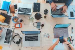 marvin-meyer-SYTO3xs06fU-unsplash view from above of meeting table with laptops and arms visible; soft skills