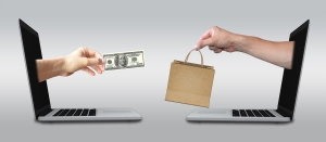 ecommerce-2140604_1280 Hands reaching toward each other from laptops. One holding money, the other holding a bag. purchasing carbon credits