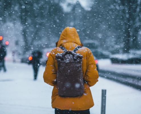 thom-holmes-9GBwZrbT0QU-unsplash person wearing a winter coat and backpack