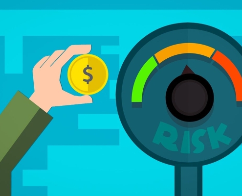 investing-4013413_1280 cartoon meter reading "risk" with colors green, orange, red and a hand holding a coin