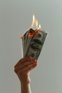 jp-valery-blOLCO2K4M0-unsplash hand holding money that is on fire; hedging - identifying risks