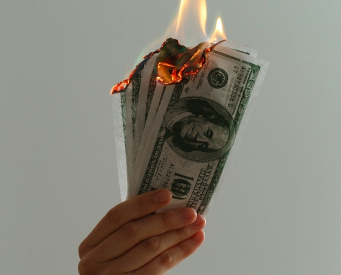 jp-valery-blOLCO2K4M0-unsplash hand holding money that is on fire; hedging - identifying risks