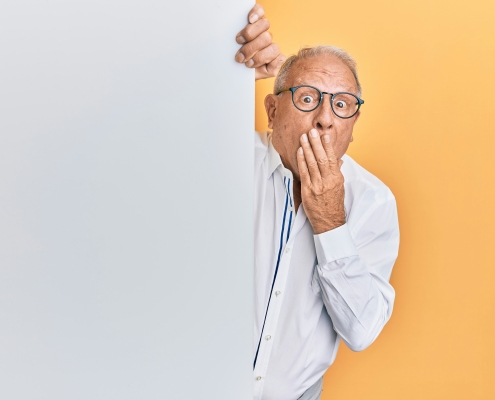 krakenimages-8RXmc8pLX_I-unsplash older man with glasses peaking around corner looking surprised; market news; tariffs