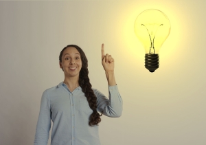 idea-4666651_1280 woman with braid holding up hand and index finger against white background, image of lightbulb to upper right of woman; soft skills matter: creativity