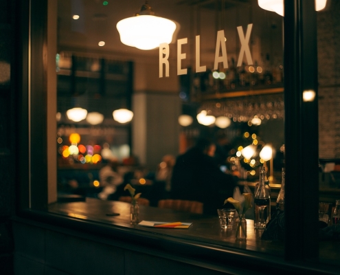 dark-2595778_1280 image of a restaurant through a window with the word relax visible; Chile