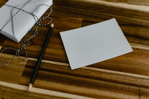 kelly-sikkema-FbDyQzVfy94-unsplash blank notecard on a brown surface, next to a pencil; sharing gratitude