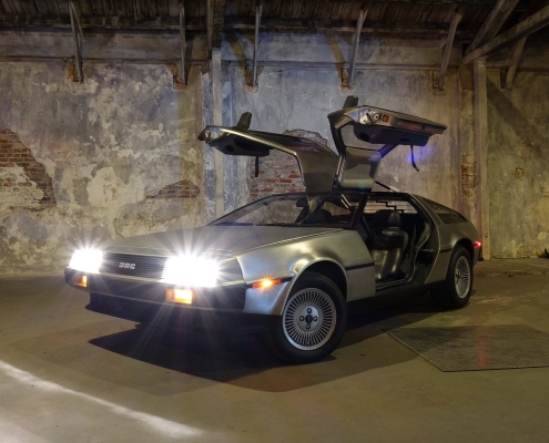 car-3249993_1280 DeLorean car with doors up and lights on in front of gray wall; What will the new year bring, market predictions for 2025