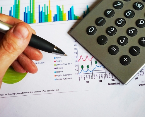 office-1574717_1280 charts and graphs on white background with calculator on top, man's hand holding pen on top; Hedging 301: financial options; year in review 2025