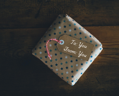 To Yout square package wrapped in brown paper with small blue stars and a tag that reads to: you, from: you; unreasonable hospitality - a gift you give yourself