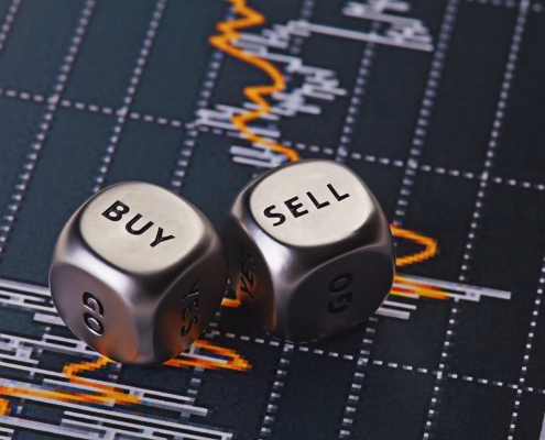 Dices cubes to trader. silver dice with words "buy" and "sell" on them on a background of financial trade info; Hedging 301 - Options - what are they?: Options -another way to use them