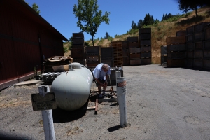 Propane Tank with Jeff Shaffer Westlark client leaning down to sniff a propane tank at a winery
