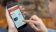 hands holding a smart phone with the word "news" visible; rising gold demand