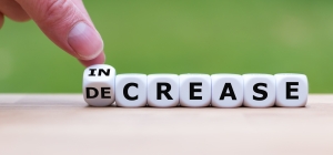Hand turns a dice and changes the word "decrease" to "increase", or vice versa. scrabble blocks spelling "decrease" with hand turning 1st block from "in" to "de"; global integration