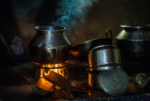 Traditional Indian village cooking on fire inside the house old metal pots on open fire in an Indian kitchen, India fuel revolution cooking