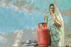 Rural Indian woman with LPG Gas Cylinder for cooking in kitchen. Empowering Women. Clean energy. India.