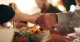two hands clasped against background of Christmas table; peace and hope at Christmas
