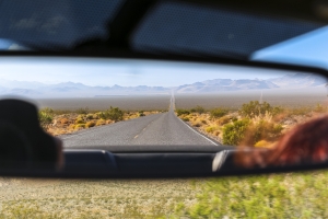 Rear mirror view on desert landscape, Nevada view of desert highway in rear view mirror; year in review 2025