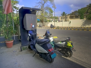 Electric Motor scooters, eco friendly mode of transport are being battery charged at a Petrol station in Mysore, India. two wheel vehicles at electric charging station in India; India Fuel Revolution autos