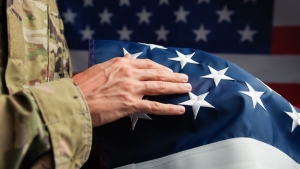 Hand of a Veteran touching stars of USA flag Veteran's hand touching the stars on the American flag; Memorial Day honor by remembering
