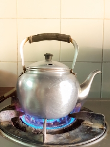 aluminium teapot boil on the old gas stove with flame aluminum kettle on gas burner; Bangladesh energy LPG